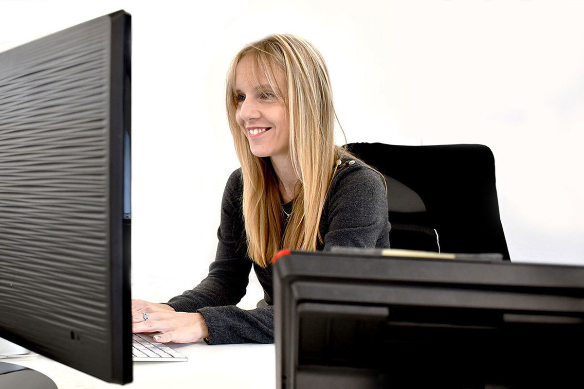 A local support worker for it'seeze happily looking at her desktop computer